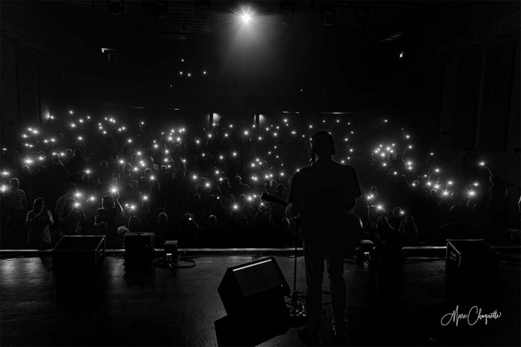 Photo noir et blanc de la foule avec la lumière de leurs cellulaires sortie